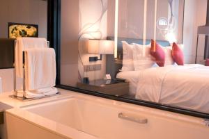 杭州杭州钱塘皇冠假日酒店的一间卧室配有一张床和一面大镜子