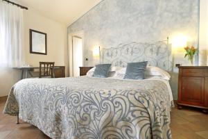 锡耶纳博尔戈格罗戴耶酒店的一间卧室配有一张带蓝色枕头的大床