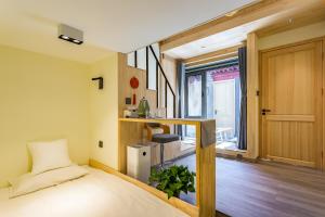 北京北京塔边四合院酒店的一间卧室设有一张床,楼梯设有窗户