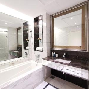 吉隆坡Dorsett Residences Kuala Lumpur的带浴缸、水槽和镜子的浴室