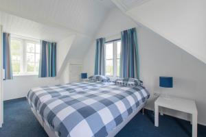 HansweertPrachtig gelegen vrijstaand landhuis的卧室设有蓝色和白色的床和窗户。