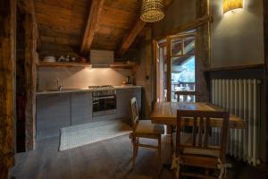 库马约尔Chalet Svizzero Apartments的一间带木桌的厨房和一间餐厅