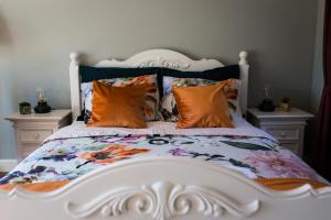 里德凯尔克B&B Wilhelmina's Cottage的一张大白色的床,上面有色彩缤纷的枕头