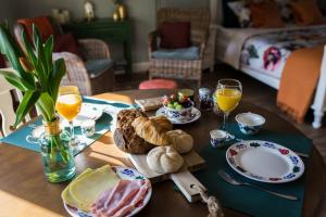 里德凯尔克B&B Wilhelmina's Cottage的桌子,上面有面包和橙汁及橙汁 ⁇ 