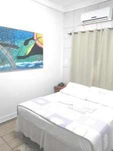 戈亚尼亚Hotel Araguaia Goiânia的卧室配有一张床,墙上挂有绘画作品