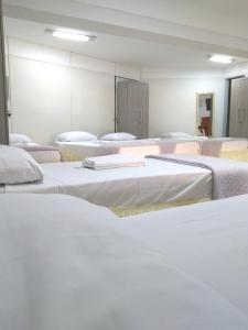 戈亚尼亚Hotel Araguaia Goiânia的一间设有一束白色床的房间