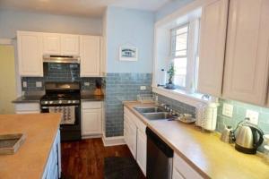 芝加哥The Greenleaf House的厨房配有白色橱柜和炉灶烤箱。