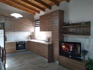 StérnaiVilla Asterousia的一间带木制橱柜和平面电视的厨房