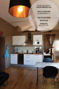 里昂莱斯托伊斯德里昂公寓的厨房配有白色橱柜和桌椅