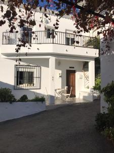 维耶亚高原Casa Cometa的带阳台和椅子的白色房屋