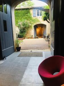 Olonzac旅行者住宿加早餐旅馆的坐在房子门口的红椅