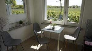 布赫霍尔茨Ferienwohnung Wiesenblick nahe Region Celle und Hannover的窗户客房内的白色桌椅