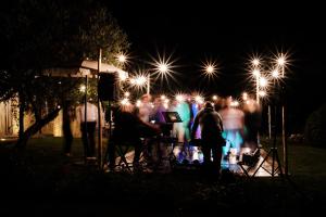 MontefollonicoCasale Santa Barbara的一群人晚上站在灯下
