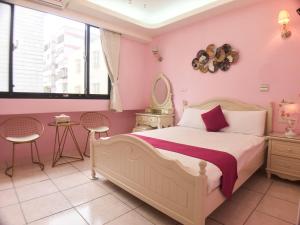 吉安花莲大碗民宿的一间卧室配有一张粉红色的墙壁和窗户。