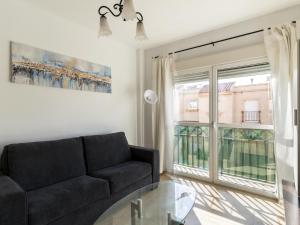 阿瓜杜尔塞Belvilla by OYO Apartment in Roquetas de Mar的带沙发和玻璃桌的客厅