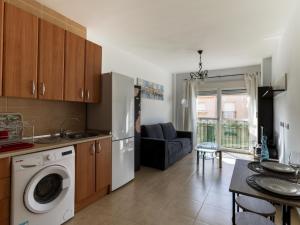 阿瓜杜尔塞Belvilla by OYO Apartment in Roquetas de Mar的一间带洗衣机的厨房和一间客厅