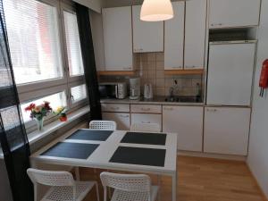 Rautavaara拉云托拉提里卡酒店的厨房配有白色橱柜和桌椅