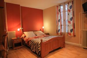 博韦季内酒店的一间卧室设有一张红色墙壁和窗户的床
