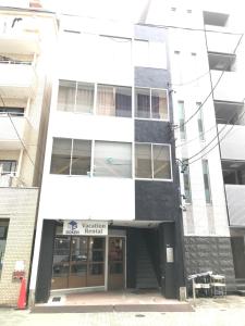 名古屋Guest House Re-worth Yabacho1 402的一座白色和黑色的建筑,设有商店