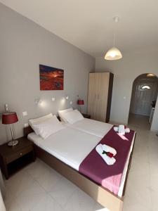 马拉希亚斯Wave Marathias Apartments的一间卧室配有一张大床和毛巾