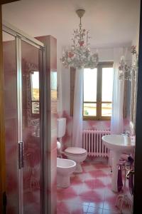 拉达-因基安蒂Dolcevita Chianti Apartments的一间带卫生间、水槽和吊灯的浴室