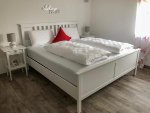 拜尔斯布龙Surrbach Chalet的卧室内配有两张带红色枕头的白色床。