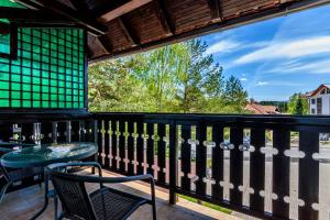 兹拉蒂博尔Apartment Vila Simovic的设有一个配有桌椅并享有美景的阳台。