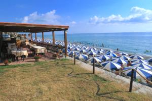 博尼法蒂Hotel Club Residence Martinica的海滩上一排蓝白遮阳伞