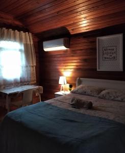 雷森迪Chalé suíte com ar em Resende的一间卧室配有一张木墙床