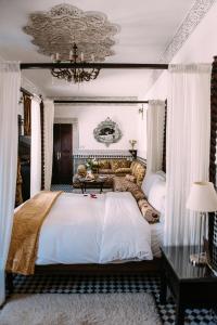 非斯里亚德大厦蓝色SPA酒店的卧室配有一张带吊灯的大型白色床。