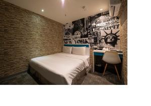 台北久居栈旅店的一间小卧室,配有一张床和一张书桌