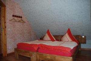汉特赫姆斯多夫FH Am Osterbrunnen的一间卧室配有红色和白色枕头的床