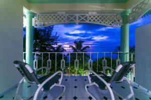 普拉兰大安塞区棕榈滩酒店的阳台配有两把椅子,享有海景。