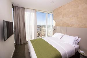 阿尔及尔阿尔及尔假日酒店 - 凯拉加塔的一间卧室设有一张大床和大窗户