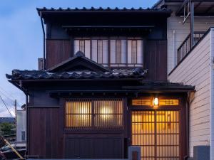 金泽Kurohoro Machiya House的一座带大木门和窗户的房子