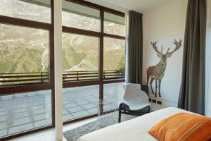 布勒伊-切尔维尼亚BASE CAMP alpine apartments的卧室设有大窗户,墙上挂着鹿