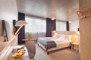 卑尔根桑德尔K酒店的酒店客房配有一张床铺和一张桌子。