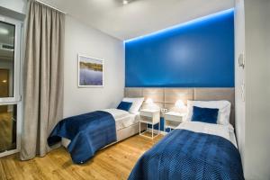RogoźnikSzafir的蓝色墙壁客房的两张床