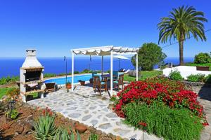 蒂哈拉费Casa Lorenzo的一个带桌子和壁炉的庭院,享有海景。