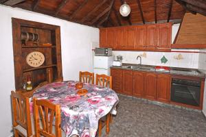 蒂哈拉费Casa Lorenzo的厨房配有桌子和墙上的时钟