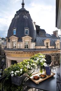 巴黎德内尔酒店的阳台与大楼之间摆放着带食物和鲜花的桌子