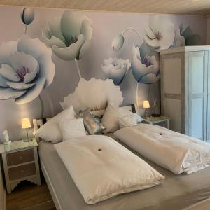 格吕克斯塔特Gästehaus Kleiner Muck的卧室配有两张挂在墙上的鲜花。