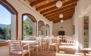 圣费柳-德帕利亚罗尔斯拉莱克托瑞尔德圣迈克尔德皮内达住宿加早餐旅馆的用餐室设有桌椅和窗户。