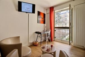 巴黎玛莱区阿希亚纳塔利豪华住宿加早餐旅馆的客厅配有电视、桌子和窗户。