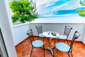 苏提万Sutivan Best Apartments的阳台配有桌椅,享有海景。