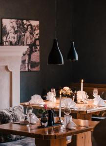 BalzhausenHotel Lenderstuben的用餐室设有木桌、蜡烛和黑色墙壁