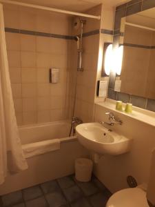 罗德兹钟楼罗德酒店的浴室配有盥洗盆、卫生间和浴缸。