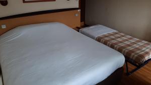 罗德兹钟楼罗德酒店的一间小卧室,配有白色的床和长凳
