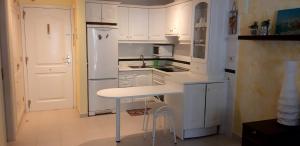 阿罗纳Residence balcon del mar的厨房配有白色橱柜和白色台面