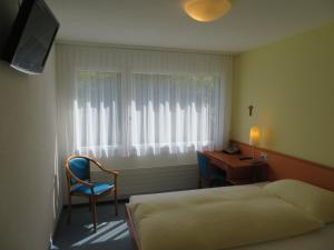 弗鲁伊利克劳森霍夫弗鲁利酒店的一间卧室配有一张床、一张书桌和一个窗户。